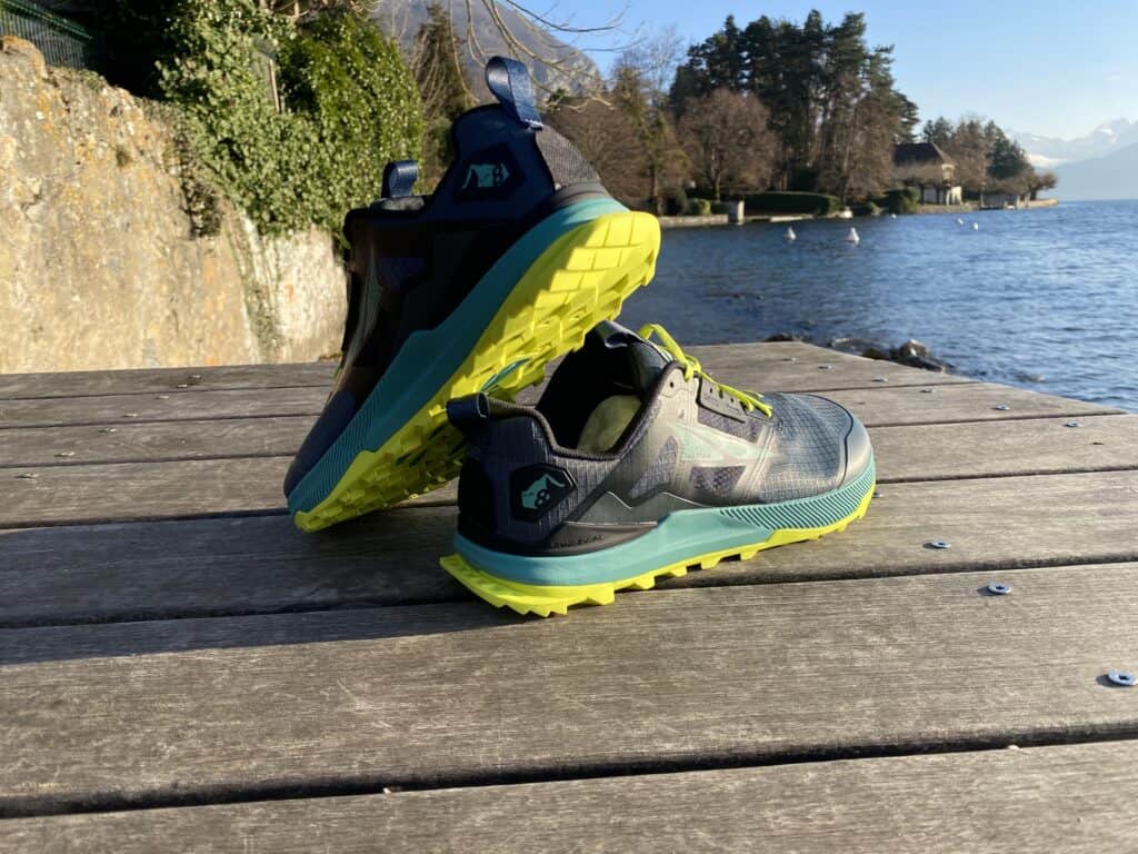 Picture of the Altra Lone Peak 8 in navy and green from the side at annecy lake